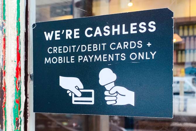 A sign on the door of a Van Leeuwen Ice Cream store that says "We're cashless. Credit/debit cards + mobile payments only.