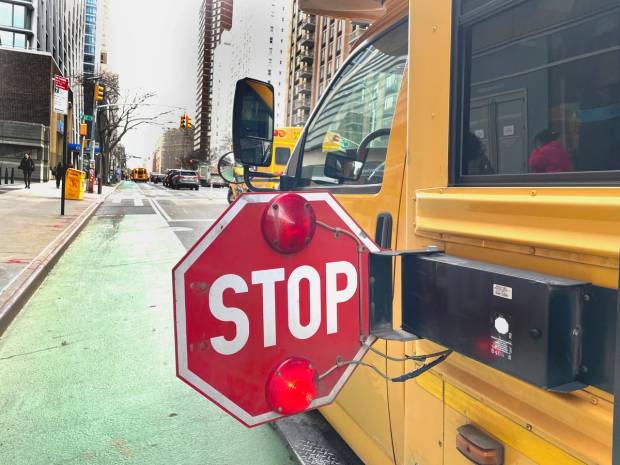 A stopped school bus with the stop sign in use