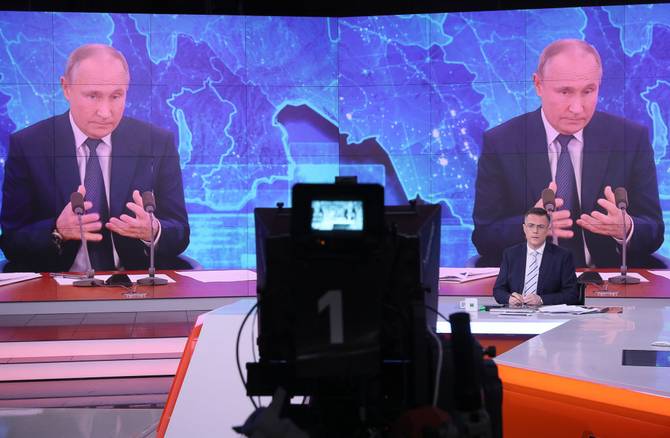 A broadcast of a Putin address is discussed in an RT television studio