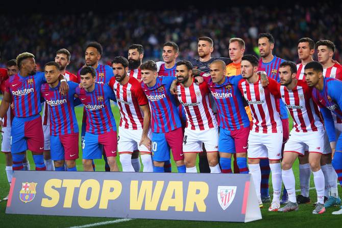 view inside the stadium as FC Barcelona and Athletic Club players pose for a photograph together with a banner reading 'Stop War' in sympathy with Ukraine