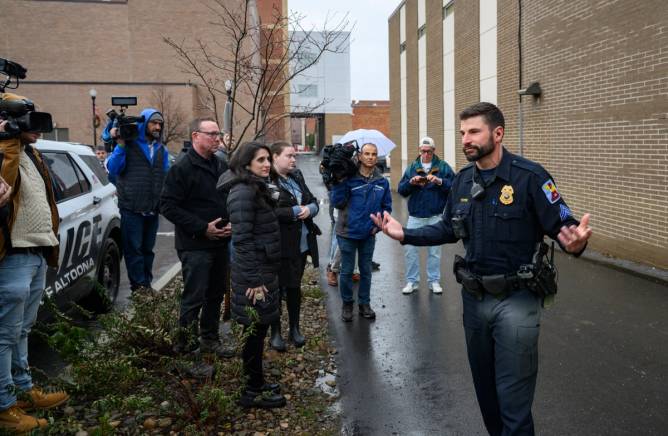 A police officer briefs members of the press