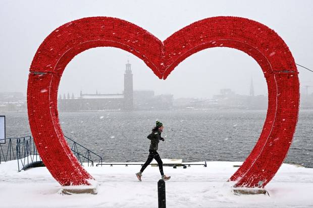 A jogger runs past a heart-shaped sculpture in frigid Stockholm, Sweden