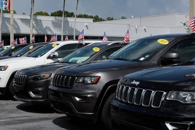 SUVs on a car lot with an American flag on each car