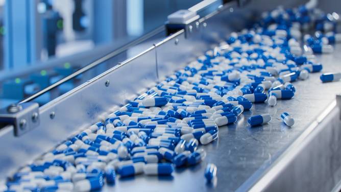 Blue and white capsules on a conveyer belt