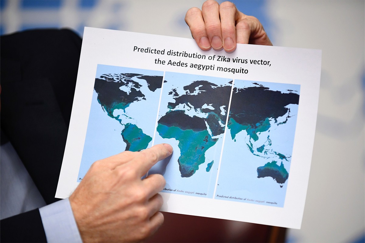 Printed map of all continents, hand points to the ocean east of Africa, portions continents highlighted.