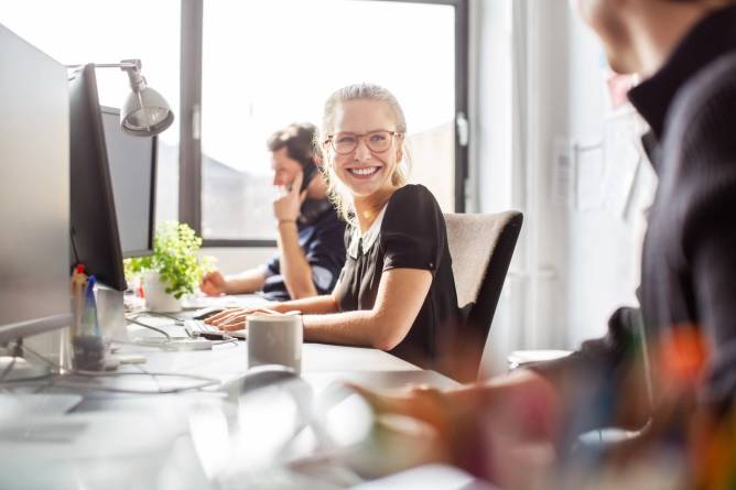 A woman co-works with her team.