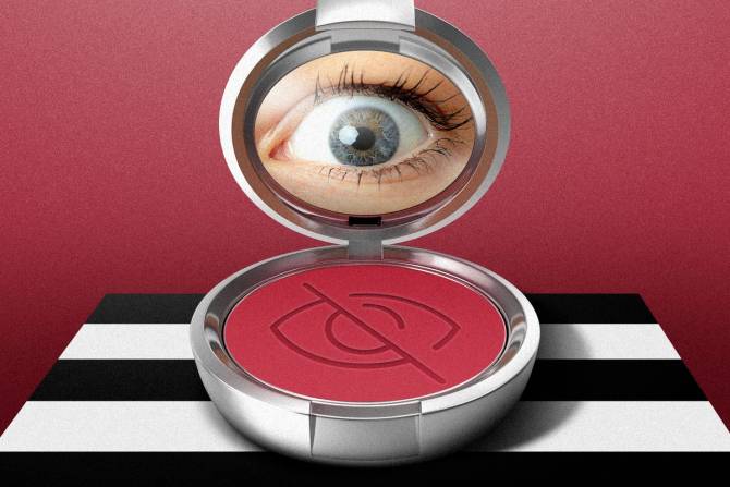 An open make-up compact with red blush sits on a black-and-white striped table, with a human eye appearing in the mirror of the compact. 