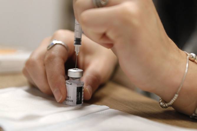 Vial of Covid-19 vaccine with a needle being stuck into it