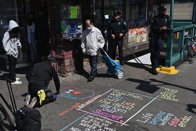Artist Honschar chalks on the sidewalk near a subway station in New York City on April 13, 2022