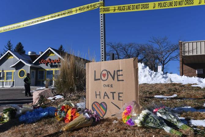 Bouquets of flowers and a sign reading "Love Over Hate" are left near Club Q, an LGBTQ nightclub in Colorado Springs, Colorado,