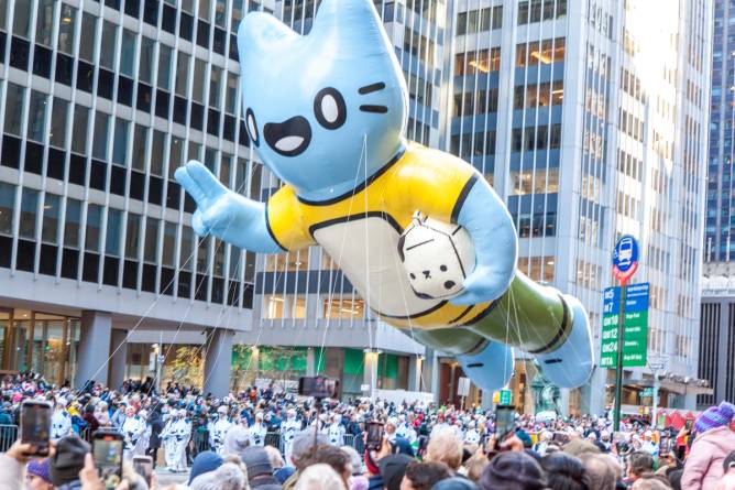 Image of individuals taking photos of a balloon during the 2023 Macy's Thanksgiving Day Parade