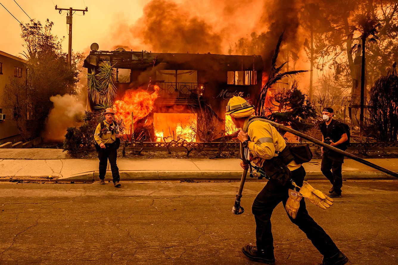 Firefighters try to extinguish a burning house