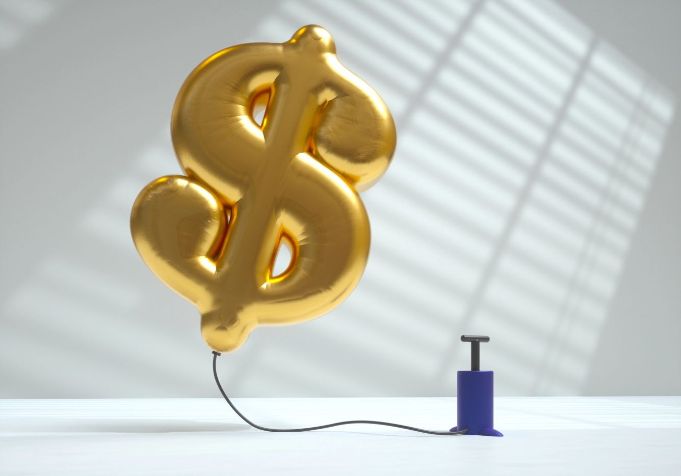 A air pump blowing up a gold balloon the shape of a dollar sign.