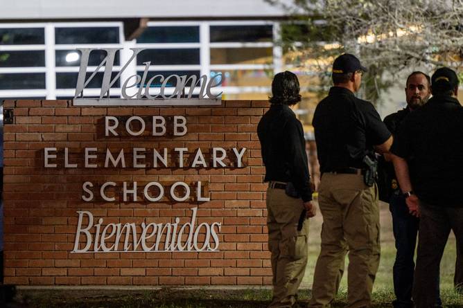 Law enforcement officers speak together outside of Robb Elementary School following the mass shooting at Robb Elementary School on May 24, 2022 in Uvalde, Texas