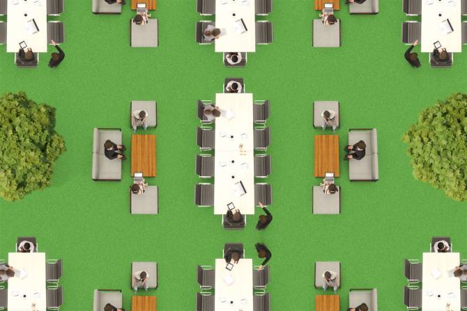 An overhead view of an open floor plan office with trees and green space