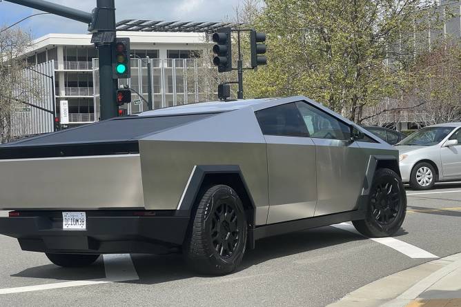 A Tesla Cybertruck drives through an intersectio