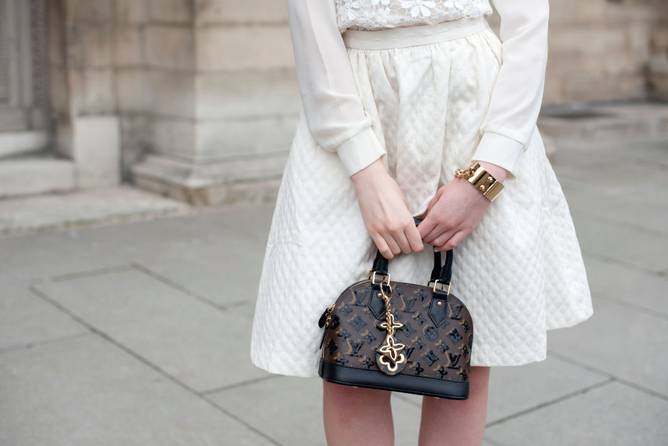 A woman dressed in Louis Vuitton with a Louis Vuitton handbag