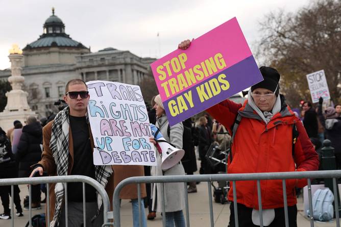 protesters stand outside the supreme court with signs