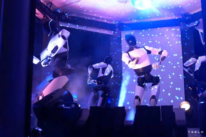 Optimus humanoid robot dancing on stage.