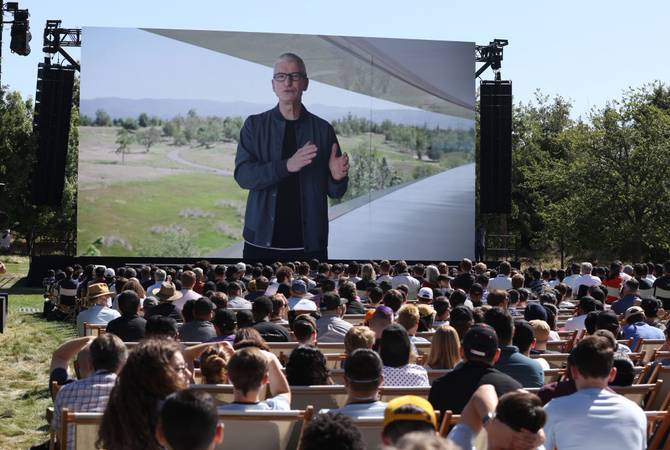 Apple CEO Tim Cook appears on a video screen as he delivers a keynote address during the WWDC22