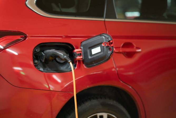 Image of a plug going into an electric vehicle