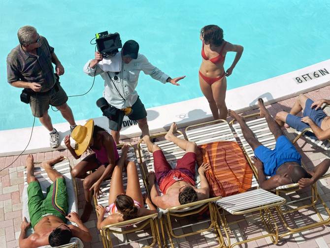 adults by pool with camera crew