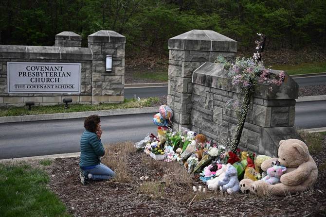 Robin Wolfenden prays at a makeshift memorial for victims outside the Covenant School building at the Covenant Presbyterian Church following a shooting, in Nashville, Tennessee,