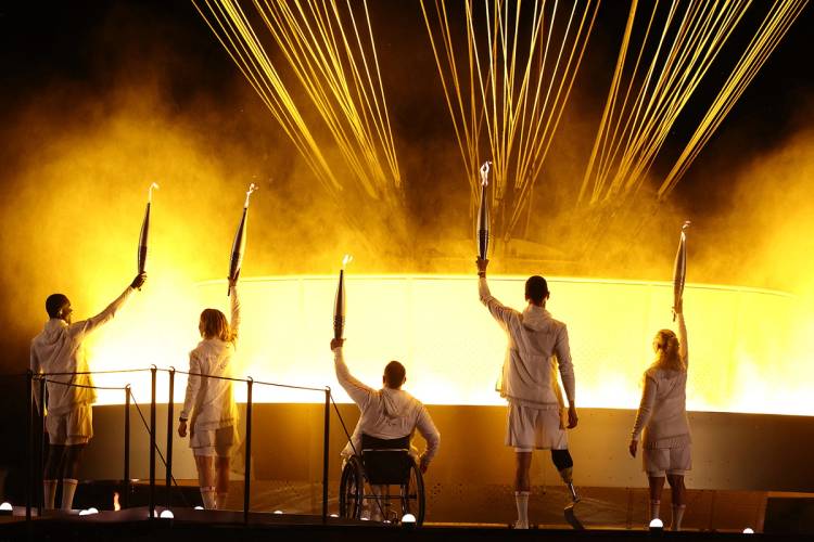 Olympic and Paralympic athletes hold Olympic torches