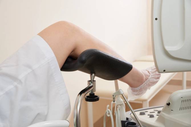 A white woman's leg is propped up in a medical office.