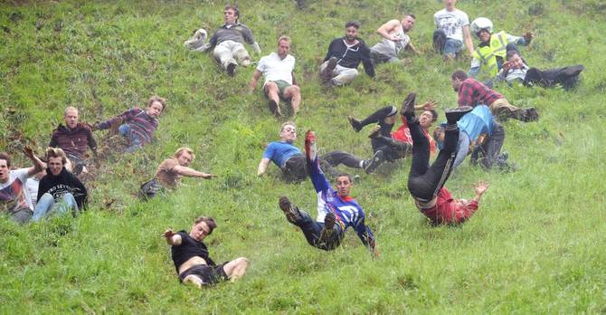 Chris Anderson (centre) wins the first race during the annual unofficial cheese rolling at Cooper's Hill in Brockworth, Gloucestershire,