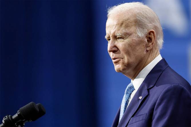 President Biden in front of a dark blue backdrop.