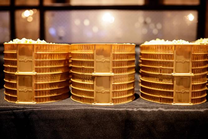 Three bronze colored popcorn buckets in the shape of a gladiator arena, sporting the "Gladiator II" movie title