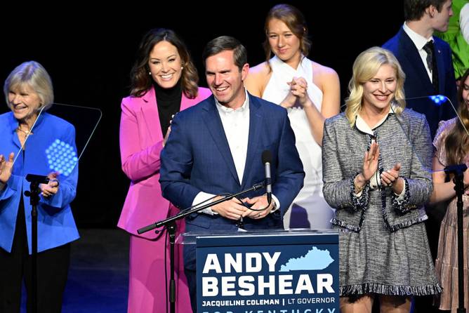 Kentucky incumbent Democratic Gov. Andy Beshear is joined by his wife, Britainy Beshear (R), Kentucky Lt. Governor Jacqueline Coleman (C-L) and his family as he delivers his victory speech to a crowd