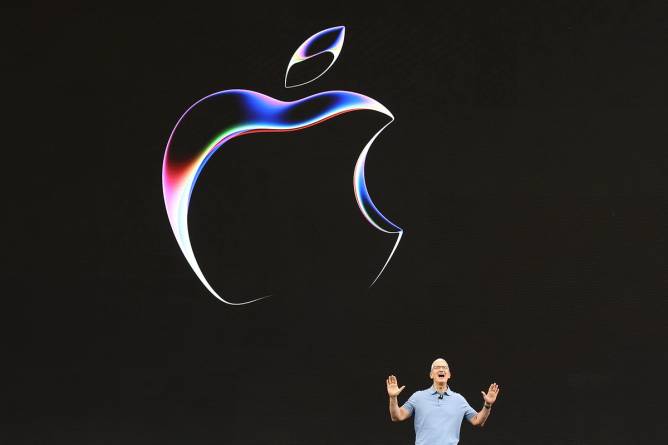 Tim Cook stands in front of an Apple icon.