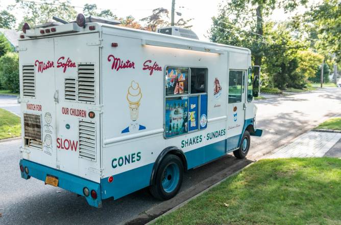 A Mr. Softee ice cream truck parked in a neighborhood. 