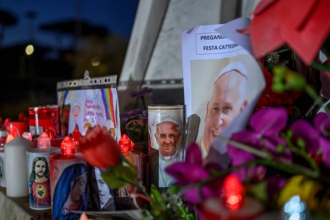 flowers and candles left outside the pope's hospital by well-wishers