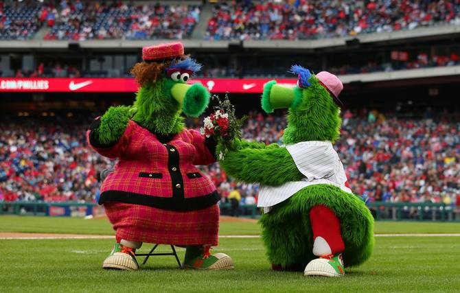 The Phillie Phanatic offers flowers to his mother Phoebe for Mother's Day during a game between the New York Mets and Philadelphia Phillies