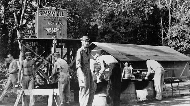 A WWII era base camp with a sign calling it Spamville. 