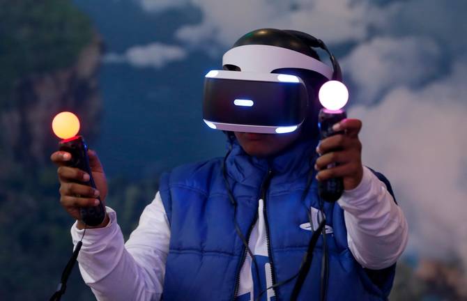 A man plays a video game with a virtual reality head-mounted headset "PlayStation VR" developed by Sony.