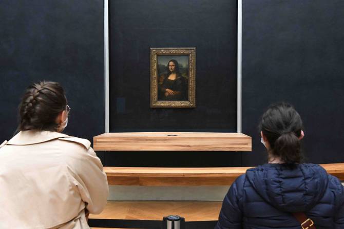 Visitors watch the painting 'Mona Lisa' at the Louvre Museum on its reopening day on May 19, 2021 in Paris, France