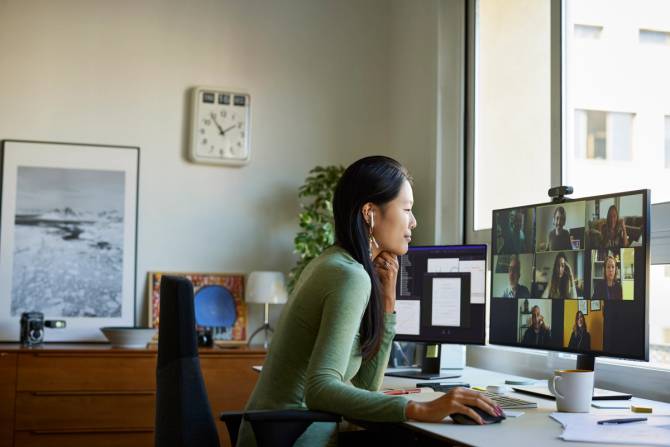 An Asian-American woman video conferences with her team.