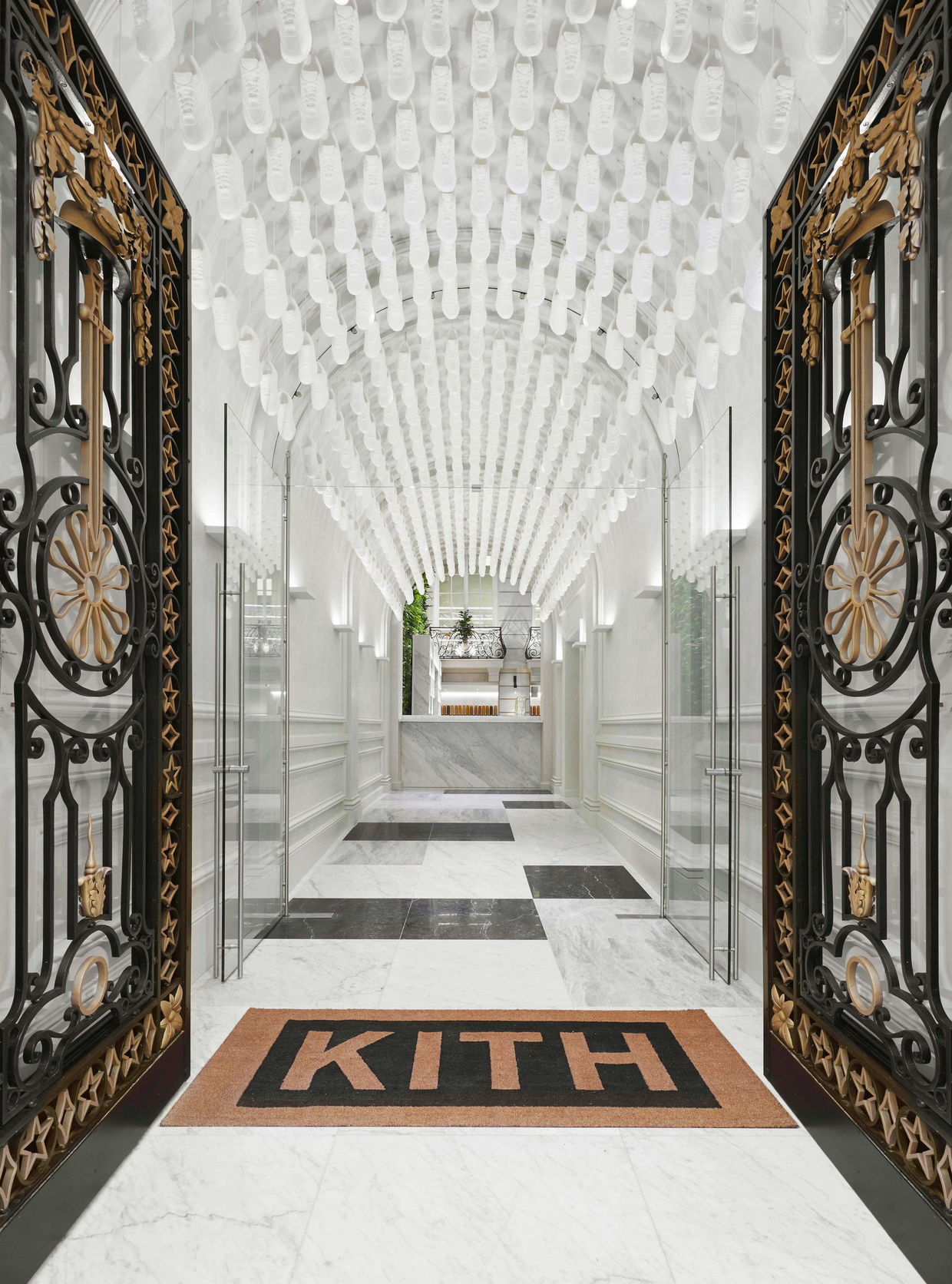 Hundreds of white sneakers hang toe-down from an arched ceiling at Kith's flagship store in Paris. 