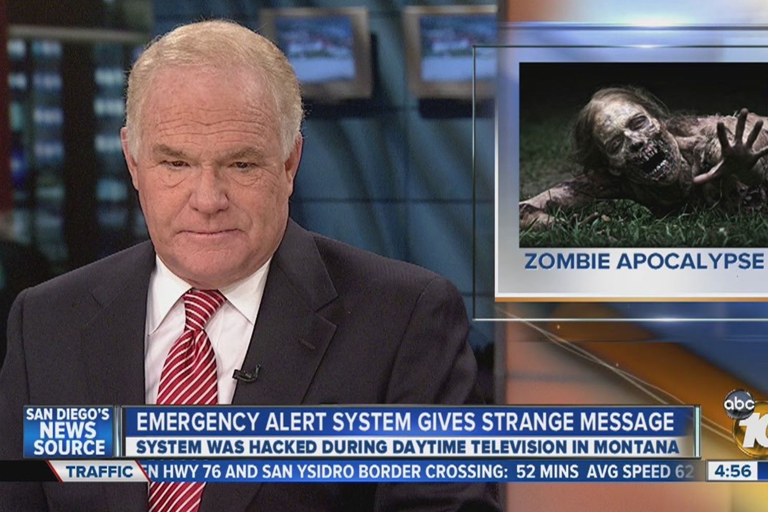 A close-up of a news anchor on air with a marquee under them that reads 'Emergency Alert System gives Strange Message.