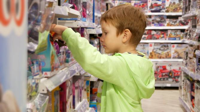 A boy choosing a toy in a toy store