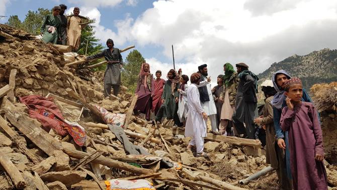 People help for the search and rescue operations on debris of a building after a magnitude 7.0 earthquake shook Afghanistan