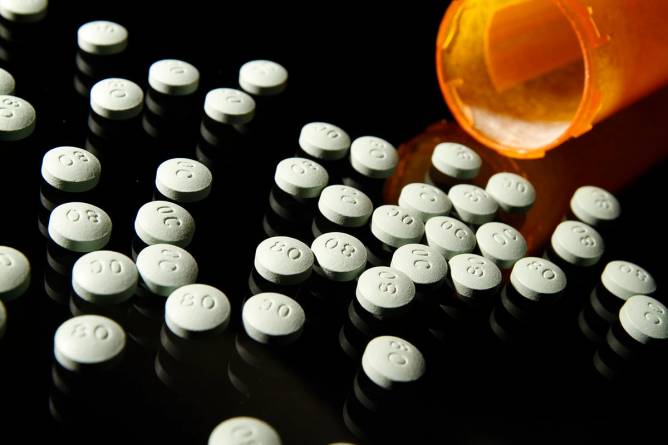 OxyContin 80 mg pills on a glass table.