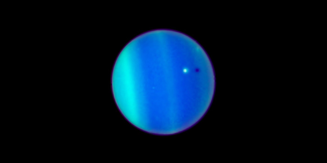 The planet Uranus. There's a white dot near the center of Uranus’ blue-green disk is the icy moon Ariel.
