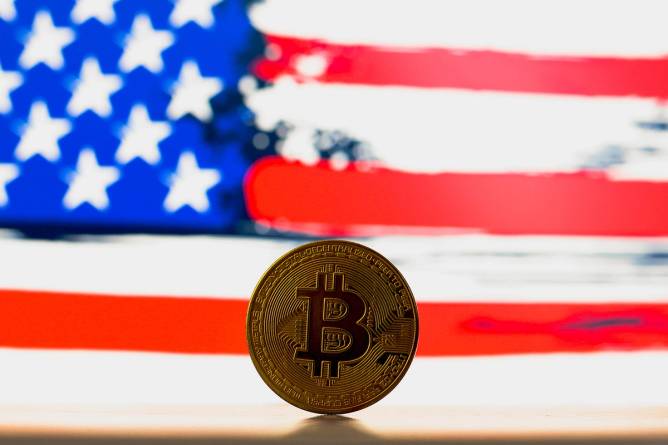 A bitcoin in front of an American flag