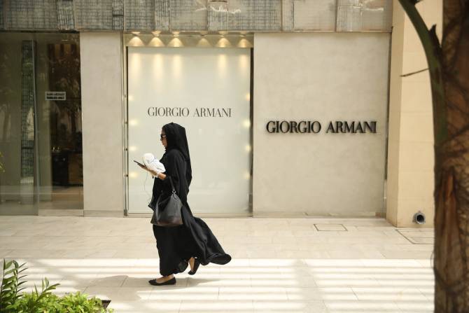 A woman walks past a Giorgio Armani shop in Saudi Arabia.