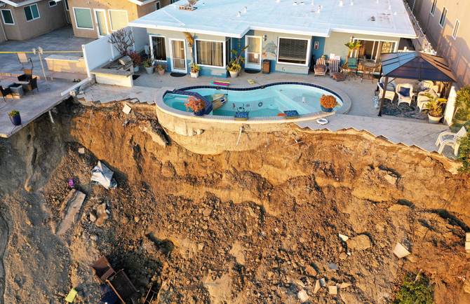 An aerial view of a remaining pool at the edge of a hillside landslide brought on by heavy rains